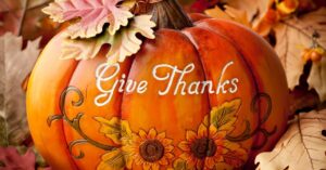 Autumn pumpkin with fall leaves and elegant scroll design featuring the words “Give Thanks” – Heartfelt Senior Solutions Thanksgiving blog symbolizing gratitude and togetherness.