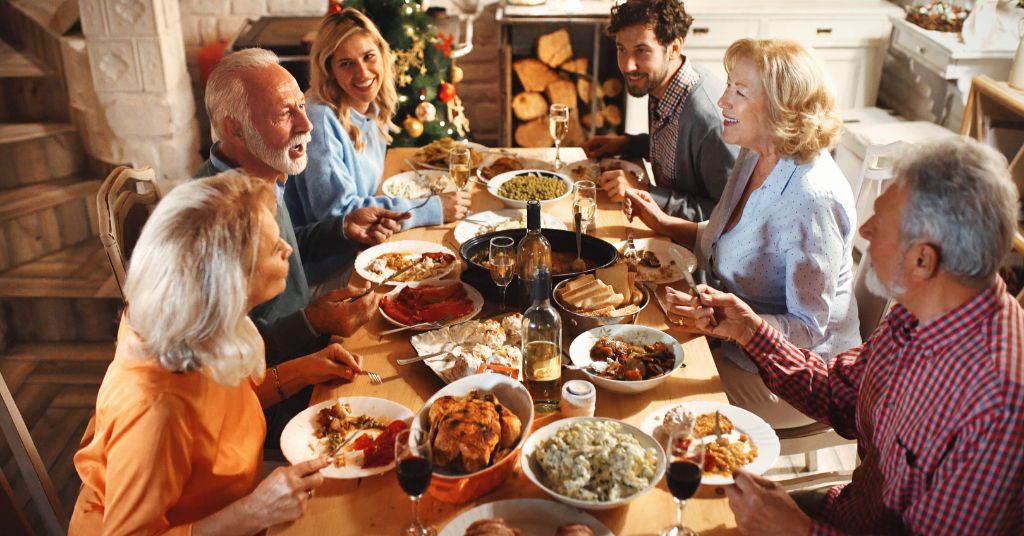 Thanksgiving family visit in senior living – family sharing a meal and smiles together – Heartfelt Senior Solutions blog