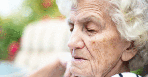 sad older woman sitting alone reflecting on signs an aging parent needs help