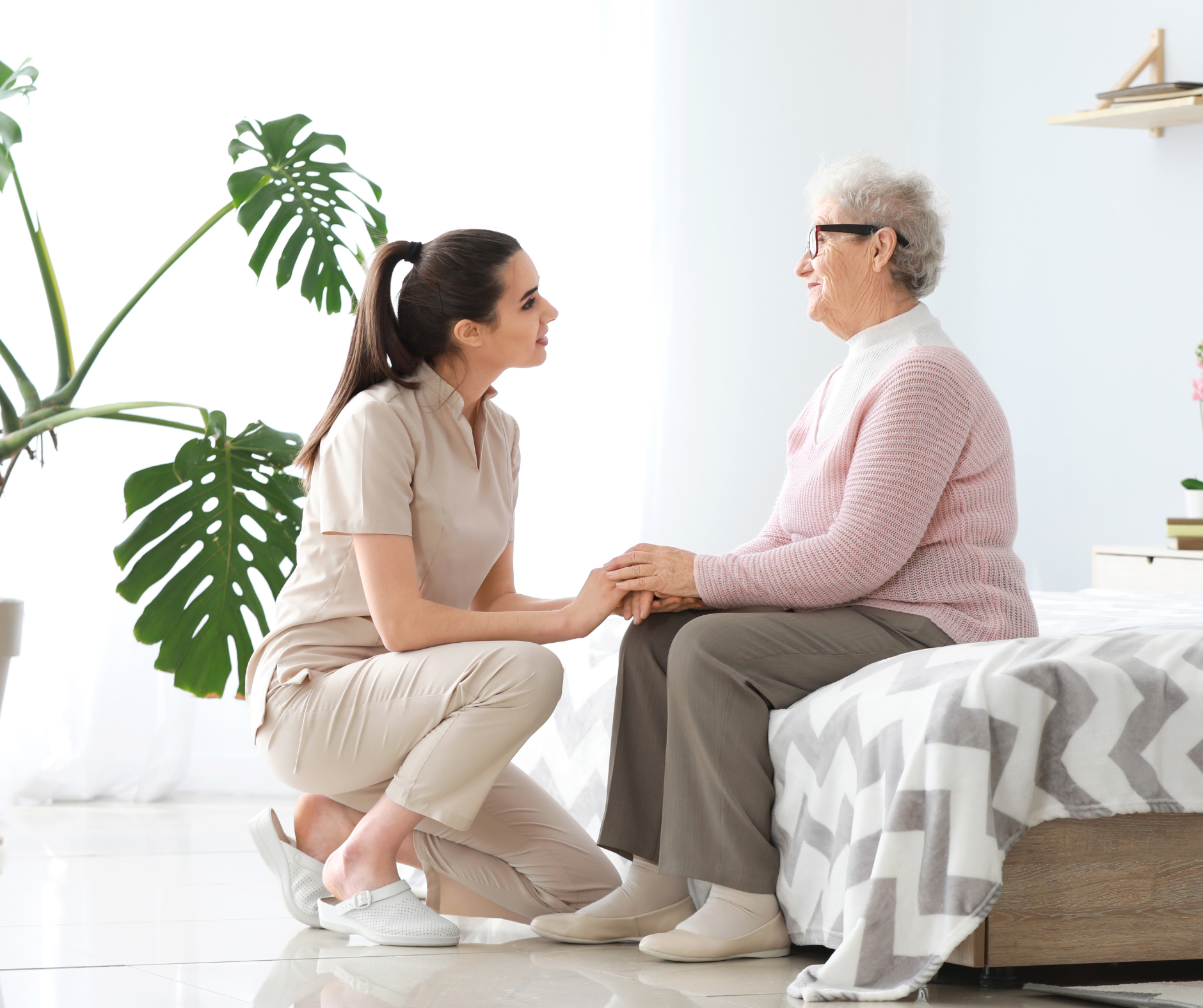 Daughter holding her aging mother's hands during a heartfelt conversation about family care decisions